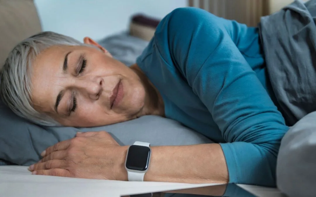 A woman asleep on a sofa, a smartwatch on her wrist